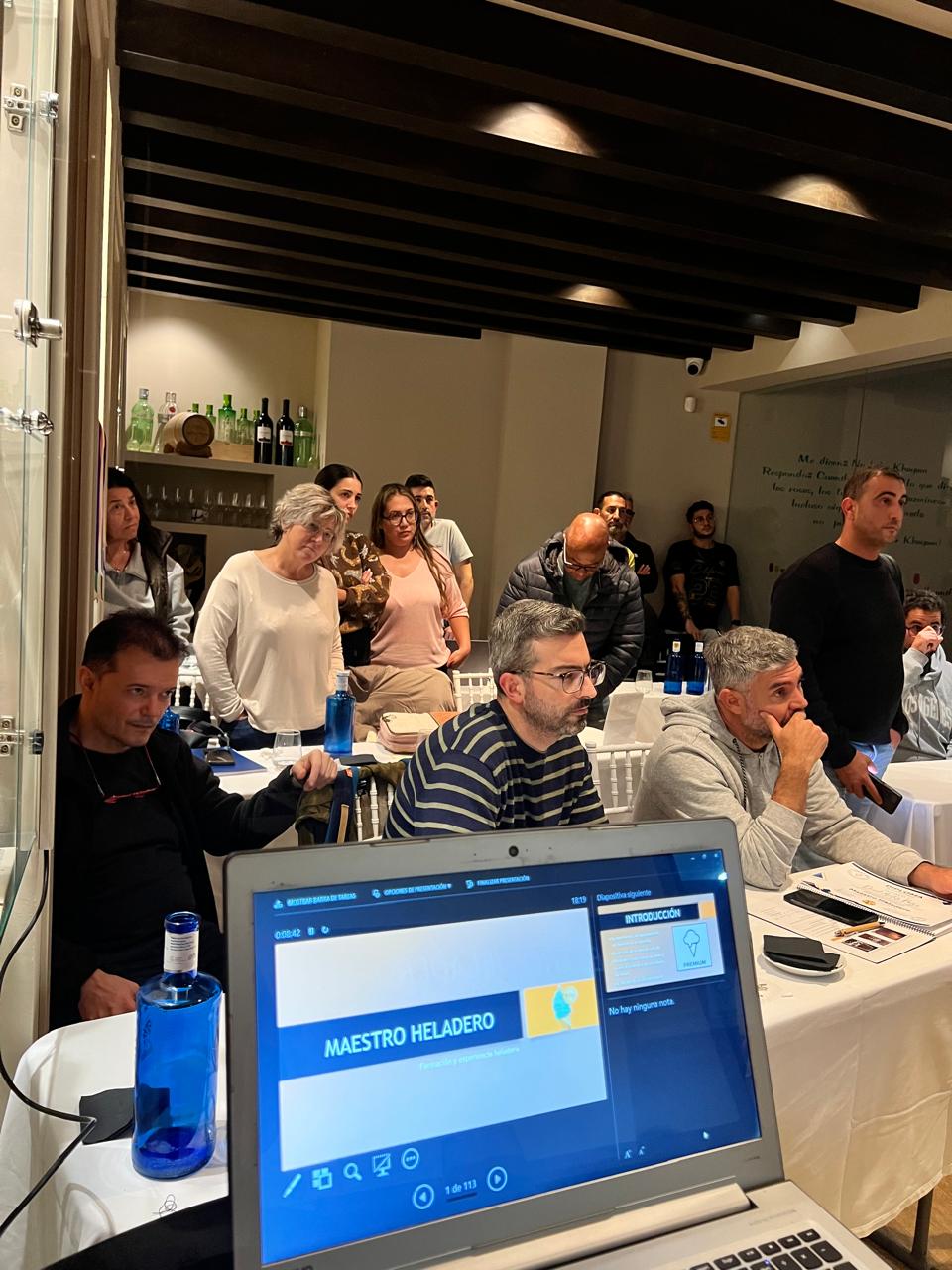 Grupo de alumnos tomando apuntes y prestando atención durante una clase de heladería