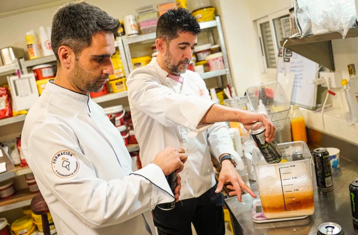 Maestros heladeros pesando ingredientes y preparando una receta en el obrador durante una clase práctica